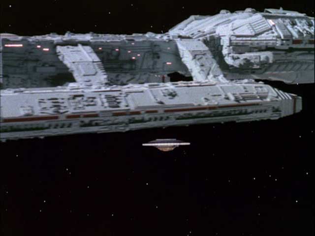 The anti-gravity ship exits Galactica, revealing the scale of the ship (1980: "Space Croppers").