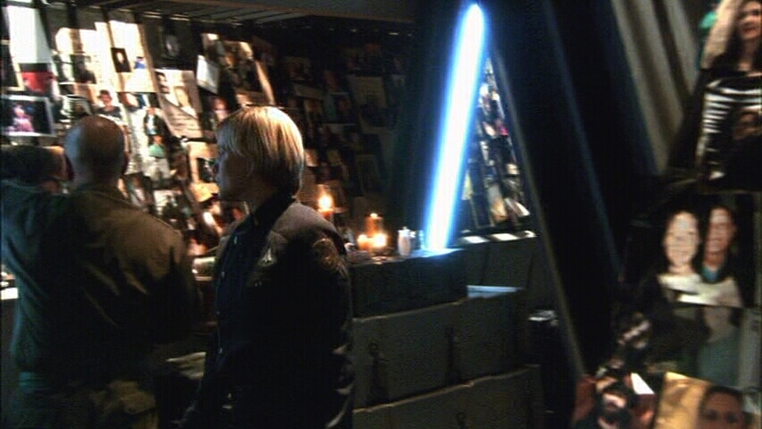 Kara Thrace and a mourning crewman at the memorial (TRS: "The Passage").