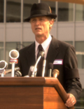 Thumbnail for File:Caprica - Rebirth - Ken at Mic.png