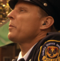 Officer Mendez wearing the standard wireless earpiece, placed only in one ear. Uniform also displays a different variant of the arm patch from pre-Armistice, noting its place in the Caprica Justice Department circa 42YR (58 BCH) (CAP: "Rebirth").