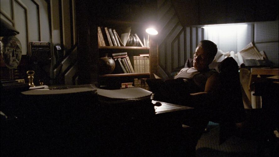 Adama's desk and a book case.