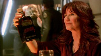 Laura Roslin begins to pass an ambrosia bottle to an intoxicated Ellen Tigh (TRS: "Tigh Me Up, Tigh Me Down").