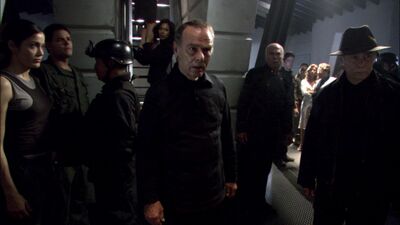 Two John Cavils, "Fleet Cavil" and "Caprica Cavil," en route to their execution as the Final Five watch their procession (TRS: "The Plan").