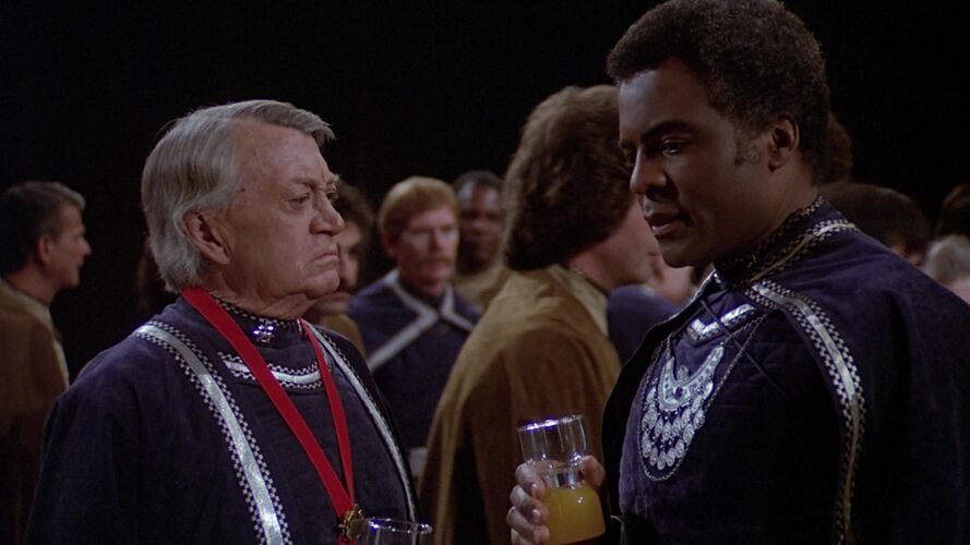 Colonel Tigh and Commander Kronus in dress uniforms.